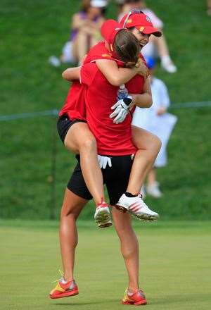 Beatriz Recari jumps into the arms of teammate Belen Mozo on the 16th green after Spain won the International Crown. PHOTO: Getty Images