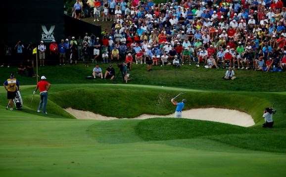 McIlroy explodes from the bunker short of the 18th green to set up a closing birdie and grab the 54-hole lead. PHOTO: Getty Images