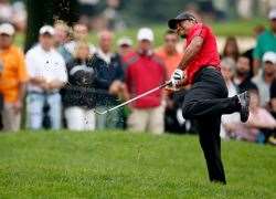 Woods grimaces as he hist through the ball. PHOTO: Getty Images