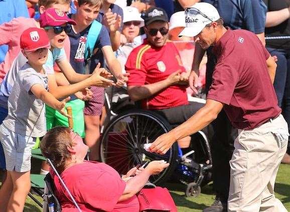 Moments after missing his putt to tie the lead, Adam Scott gives his ball to a fan in a wheelchair beside the 18th green. PHOTO: Getty Images.