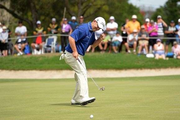 Greg Chalmers walks in his birdie putt on the 18th hole that put him at the top of the leaderboard. PHOTO: Getty Images.