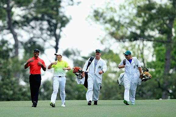 Tiger Woods and Rory McIlroy of Northern Ireland share a joke as they walk down the 9th fairway during the final round. PHOTO: Getty Images.