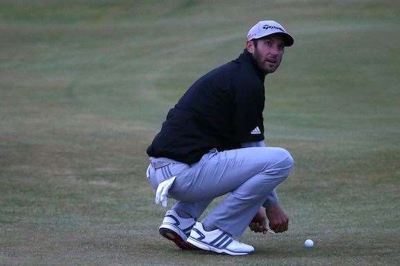 Dustin Johnson marks his ball on the 14th hole as play ends for the day. PHOTO: Streeter Lecka/Getty Images.