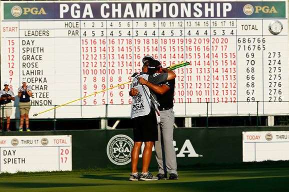 Job done ... Day hugs his caddie and mentor Col Swatton on the 18th green after tapping in for the win. PHOTO: Jamie Squire/Getty Images.