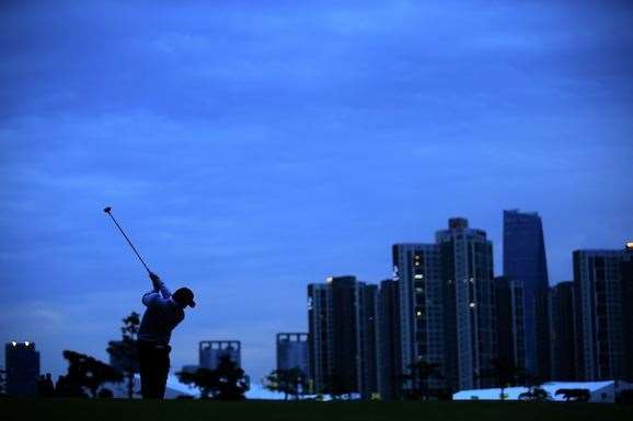Louis Oosthuizen plays his second shot on the 18th hole in close to complete darkness. PHOTO: David Cannon/Getty Images.