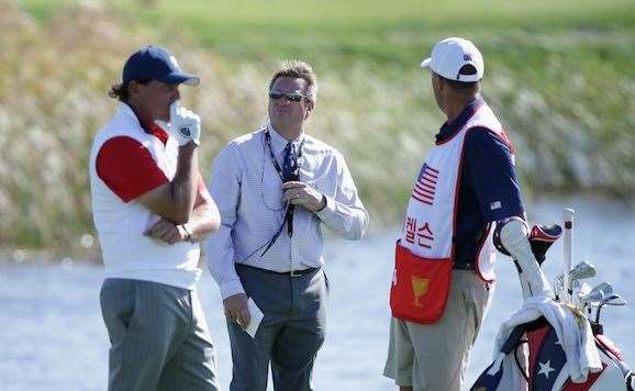 Phil Mickelson confers with his caddie Jim Mackay as rules official Gary Young looks on during the four-ball matches. PHOTO: Chung Sung-Jun/Getty Images.