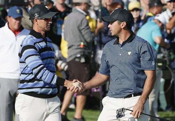 Adam Scott and Jason Day shake hands after gaining a valuable half point from their match. PHOTO: Chung Sung-Jun/Getty Images.
