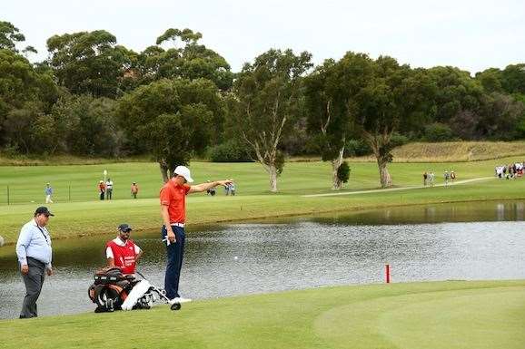 Jordan Spieth takes a drop on the 3rd hole after hitting into the water. PHOTO: Matt King/Getty Images.