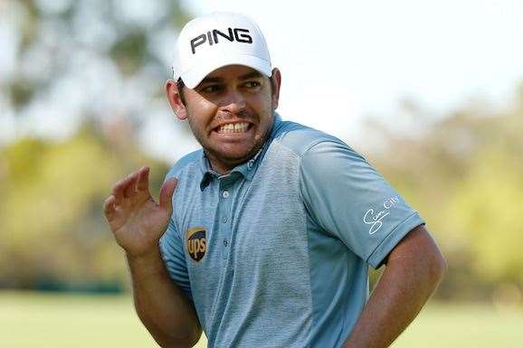 Oosthuizen reacts after throwing his ball into the gallery on the 18th green. PHOTO: Paul Kane/Getty Images.