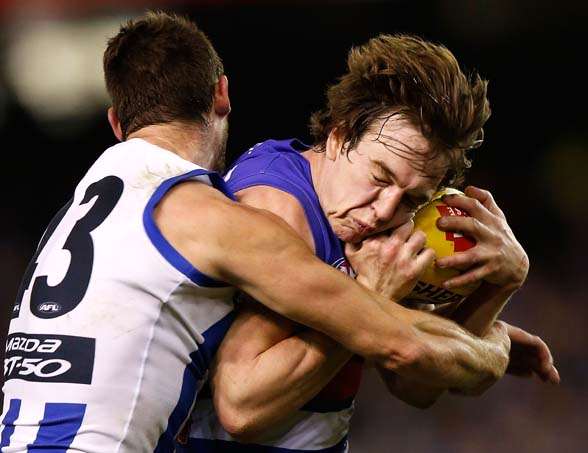 MELBOURNE, AUSTRALIA - AUGUST 29: Liam Picken of the Bulldogs is tackled by Sam Gibson of the Kangaroos during the 2015 AFL round 22 match between the North Melbourne Kangaroos and the Western Bulldogs at Etihad Stadium, Melbourne, Australia on August 29, 2015. (Photo by Michael Willson/AFL Media/Getty Images)