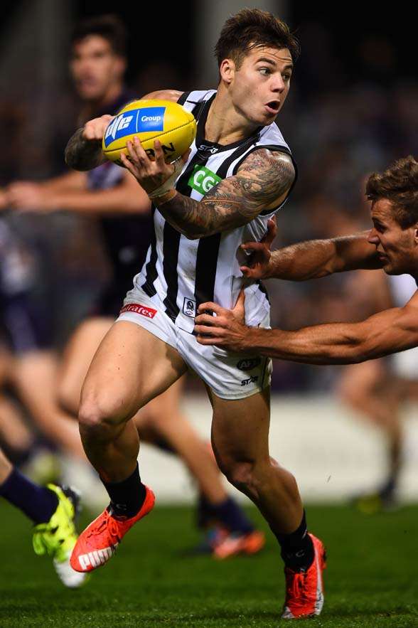 PERTH, AUSTRALIA - JUNE 25: Jamie Elliott of the Collingwood Magpies looks to handball under pressure from Matt de Boer of the Fremantle Dockers during the 2015 AFL round thirteen match between the Fremantle Dockers and the Collingwood Magpies at Domain Stadium on June 25, 2015 in Perth, Australia. (Photo by Daniel Carson/AFL Media/Getty Images)
