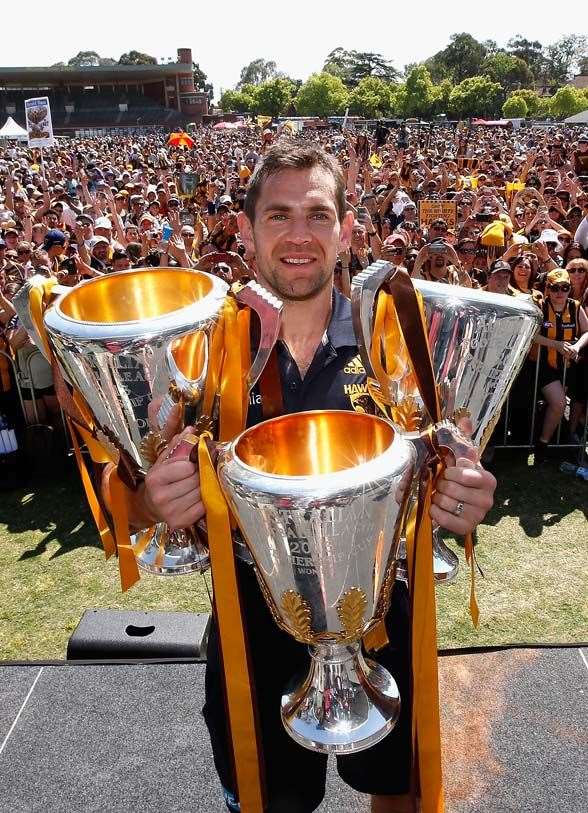 MELBOURNE, VICTORIA - OCTOBER 04: Luke Hodge the captian of the Hawks poses with the 2013, 2014 and 2015 premiership trophies during the Hawthorn Hawks AFL Grand Final fan day at Glenferrie Oval on October 4, 2015 in Melbourne, Australia. (Photo by Quinn Rooney/Getty Images)