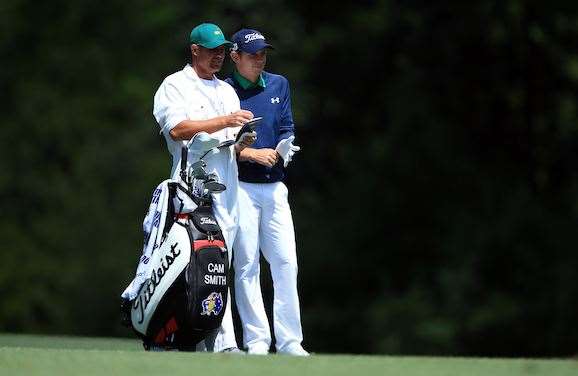 Cam Smith and caddie Sam Pinfold discuss the options for Smith’s second shot to the 5th hole on Friday. PHOTO: David Cannon/Getty Images