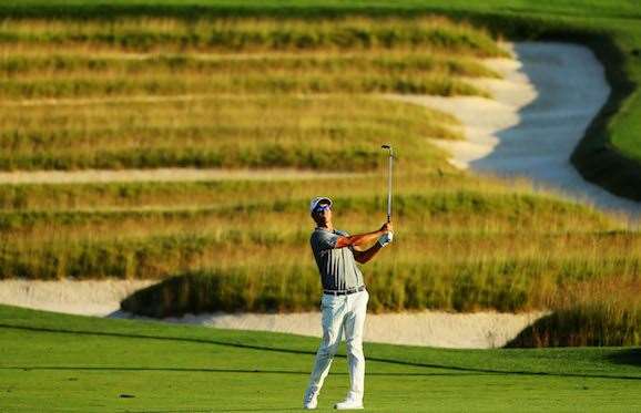 Adam Scott plays his approach shot on the 3rd hole during the second round. He will have three holes to play early on Saturday morning. PHOTO: Andrew Redington/Getty Images.