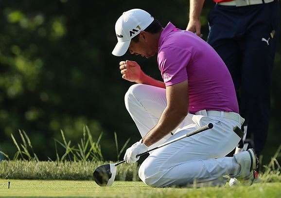 Jason Day drops to the ground after his tee shot on the 17th hole finds sand. PHOTO: David Cannon/Getty Images.