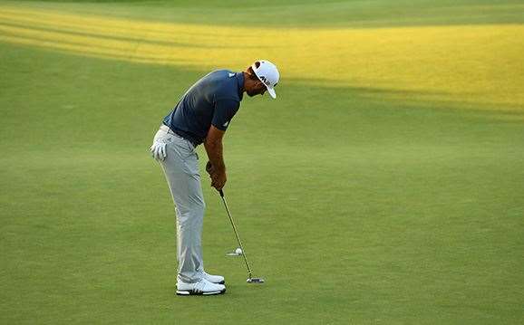 Johnson makes birdie on the 18th green to seal the deal. PHOTO: Ross Kinnaird/Getty Images.