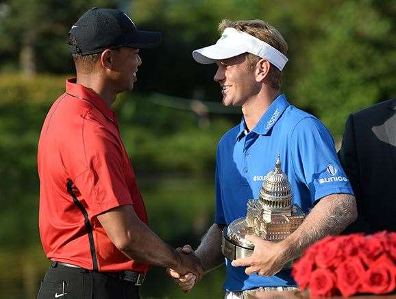 Billy Hurley shakes hands with tournament host Tiger Woods during the trophy presentation. PHOTO: Andrew Caballero-Reynolds/AFP/Getty Images.