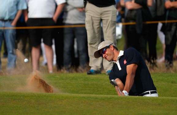 Adam Scott hits out of a bunker shot on the 16th to set up a birdie. PHOTO: Kevin C. Cox/Getty Images.