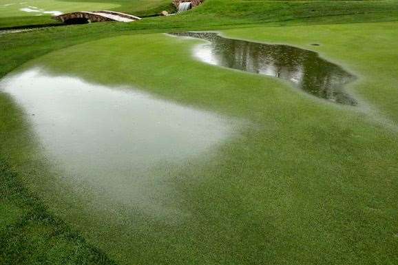 Puddles start to form on the 18th hole while play is suspended due to inclement weather. PHOTO: Andy Lyons/Getty Images.