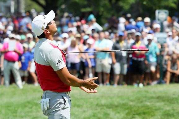 Jason Day tosses his putter on the 9th green after just missing a putt. He says he's happy with his opening round 68. PHOTO: Andrew Redington/Getty Images.