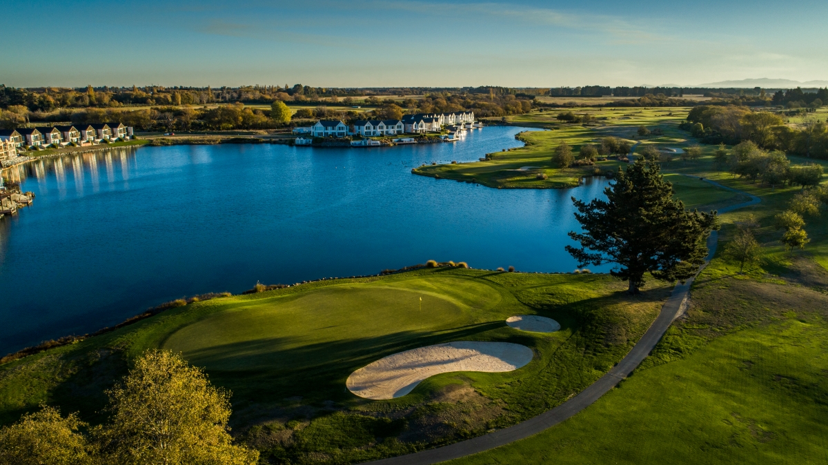 The par-3 9th hole at Clearwater Golf Club Christchurch surrounded by water and a greenside bunker with the challenge of 188 metres from the championship tees and panoramic views of the Canterbury landscape