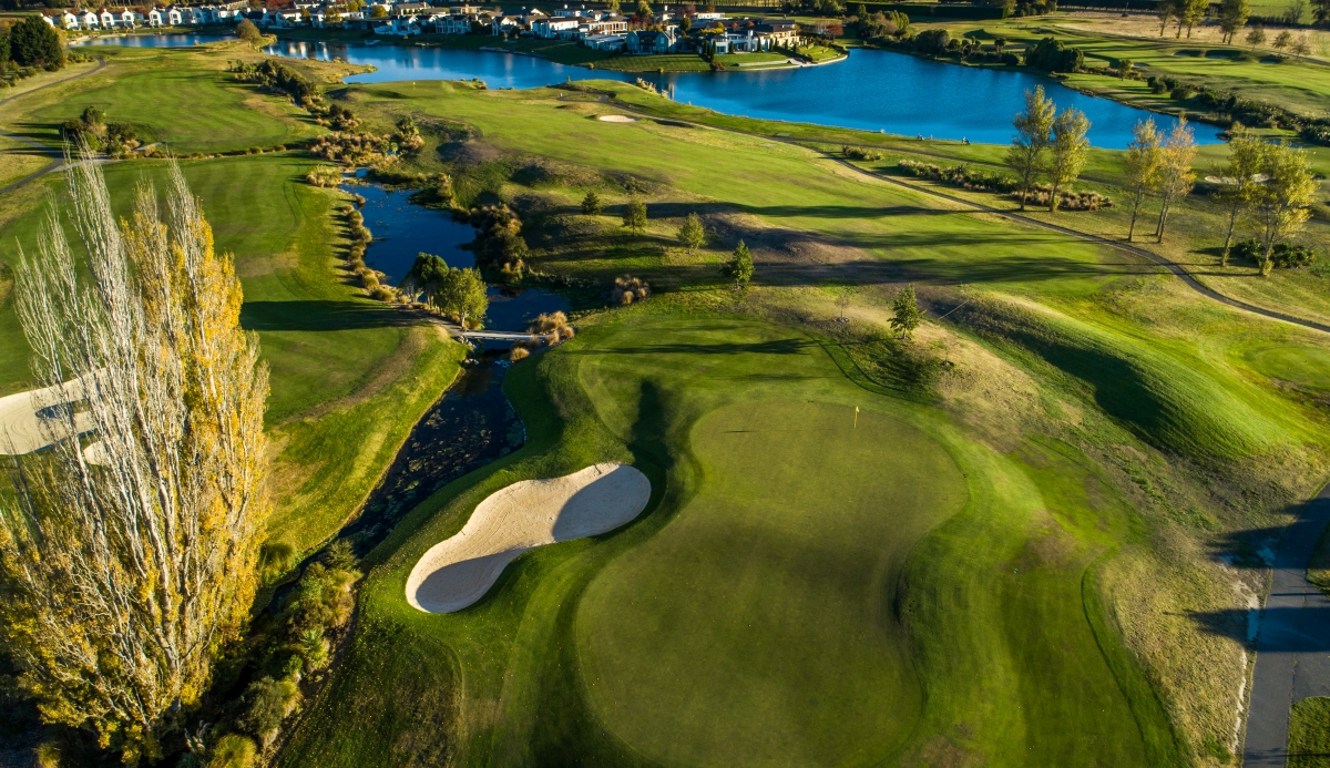 The 14th hole at Clearwater Golf Club showing the double-carry par-5 fairway with hidden burns splitting the approach and the funnel green in the distance surrounded by spring-fed water hazards