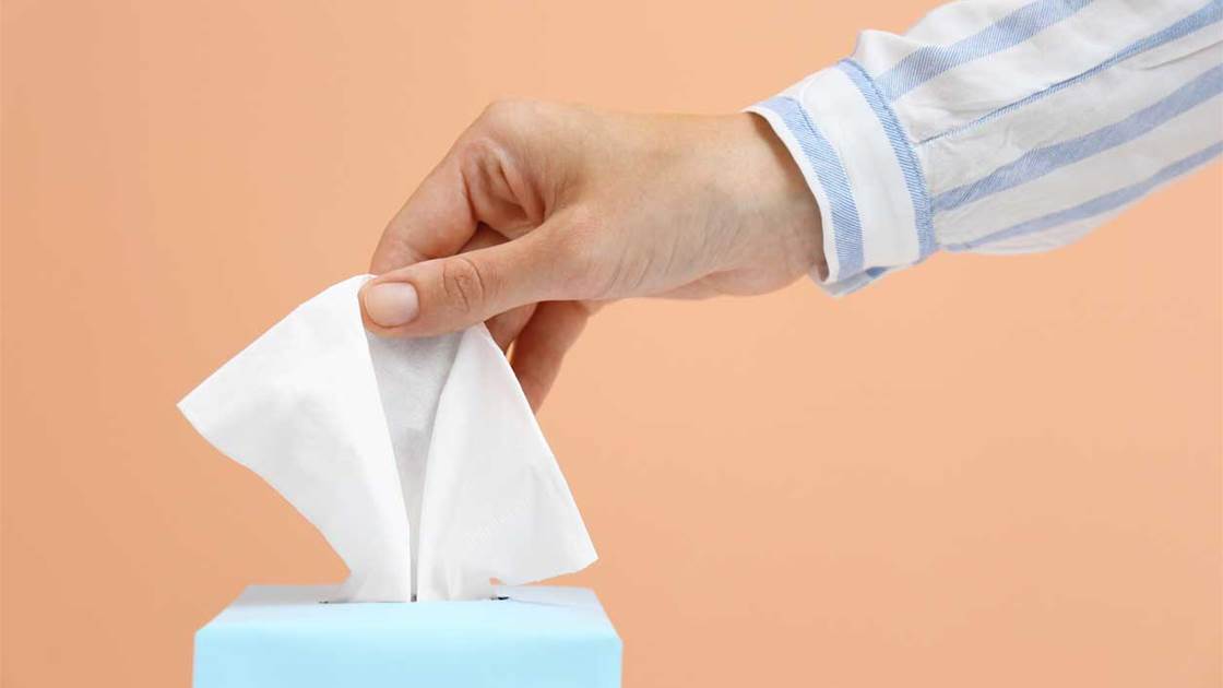 Woman reaching for a tissue, signifying the immune system. Woman reaching for a tissue, signifying the immune system.
