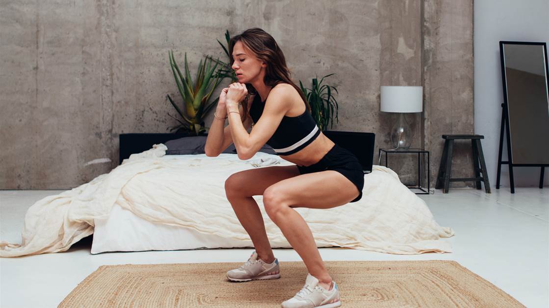 Woman doing squats at home for knee strength and mobility Woman doing squats at home for knee strength and mobility