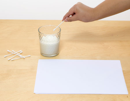 Dip the cotton bud in the milk